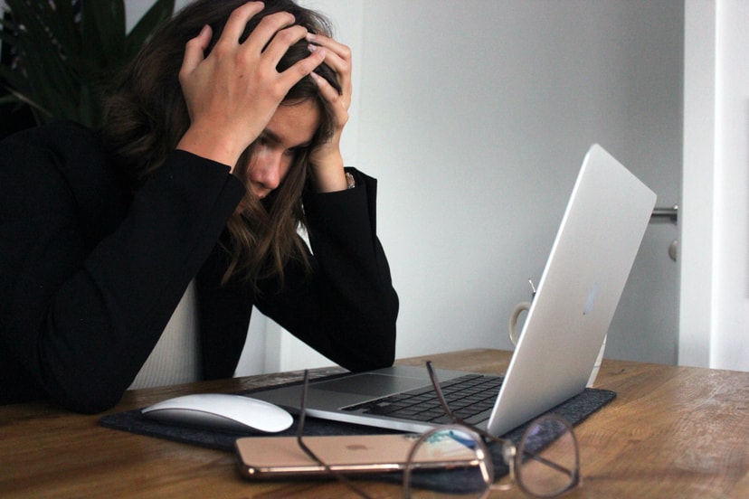Writer with hands in head in front of a laptop